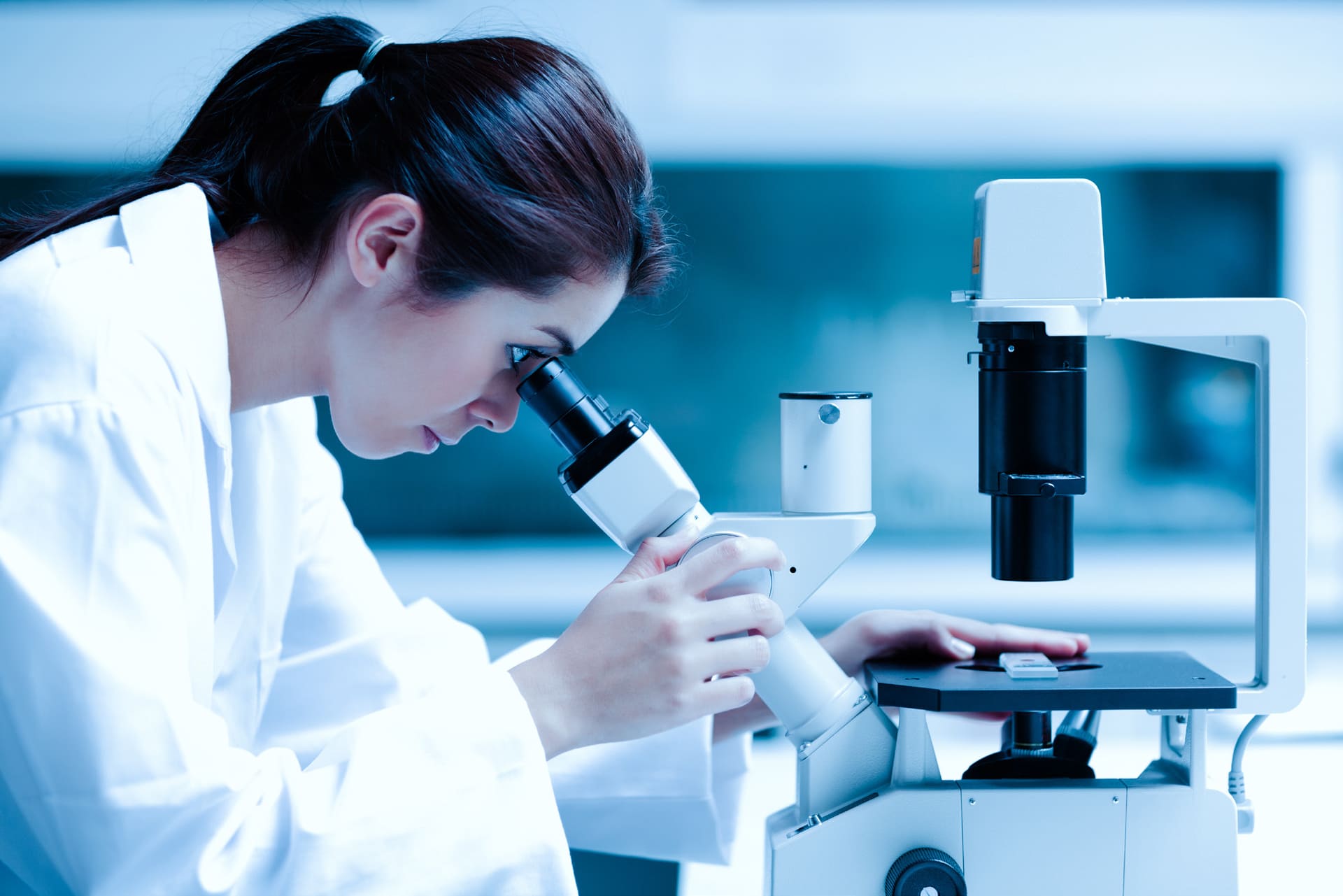 woman looking into microscope